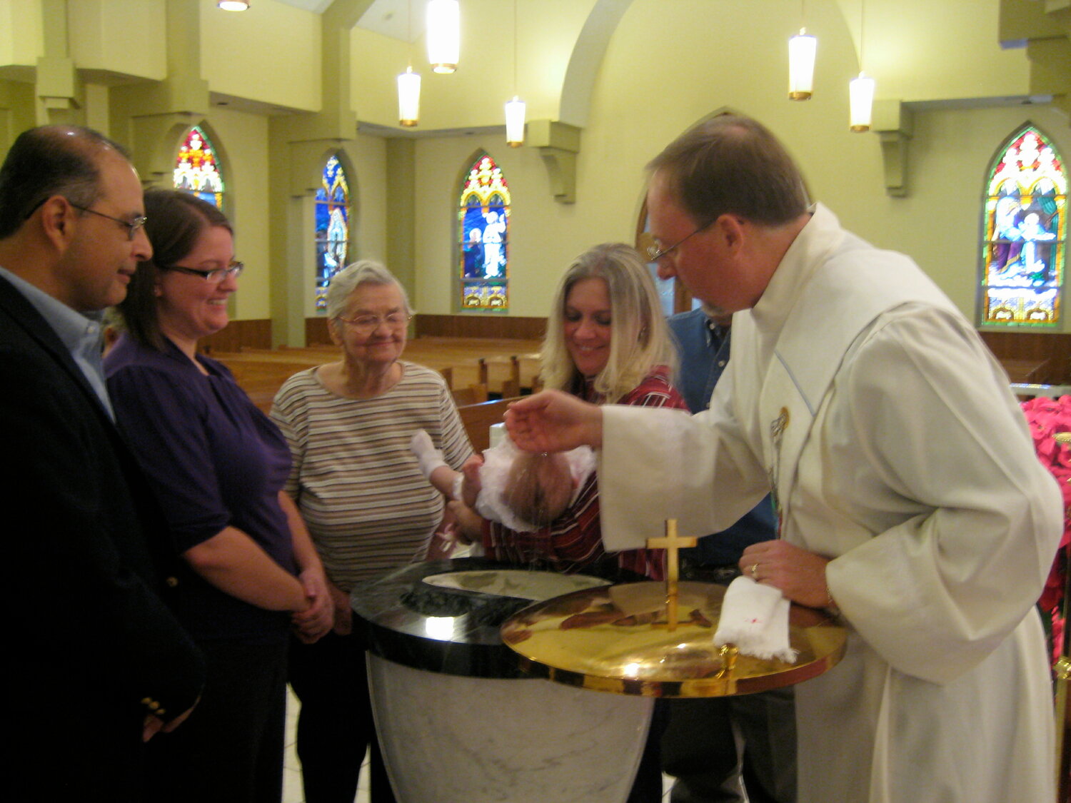 A deacon baptizes a baby.